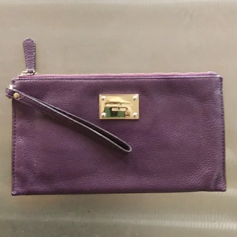 Gently used MICHAEL KORS plum color leather wristlet. Almost perfect condition.